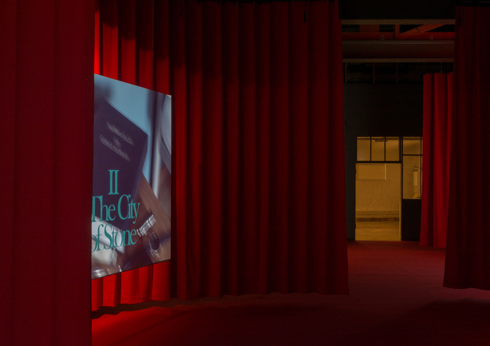 Three-channel Augustijn installation behind red curtains