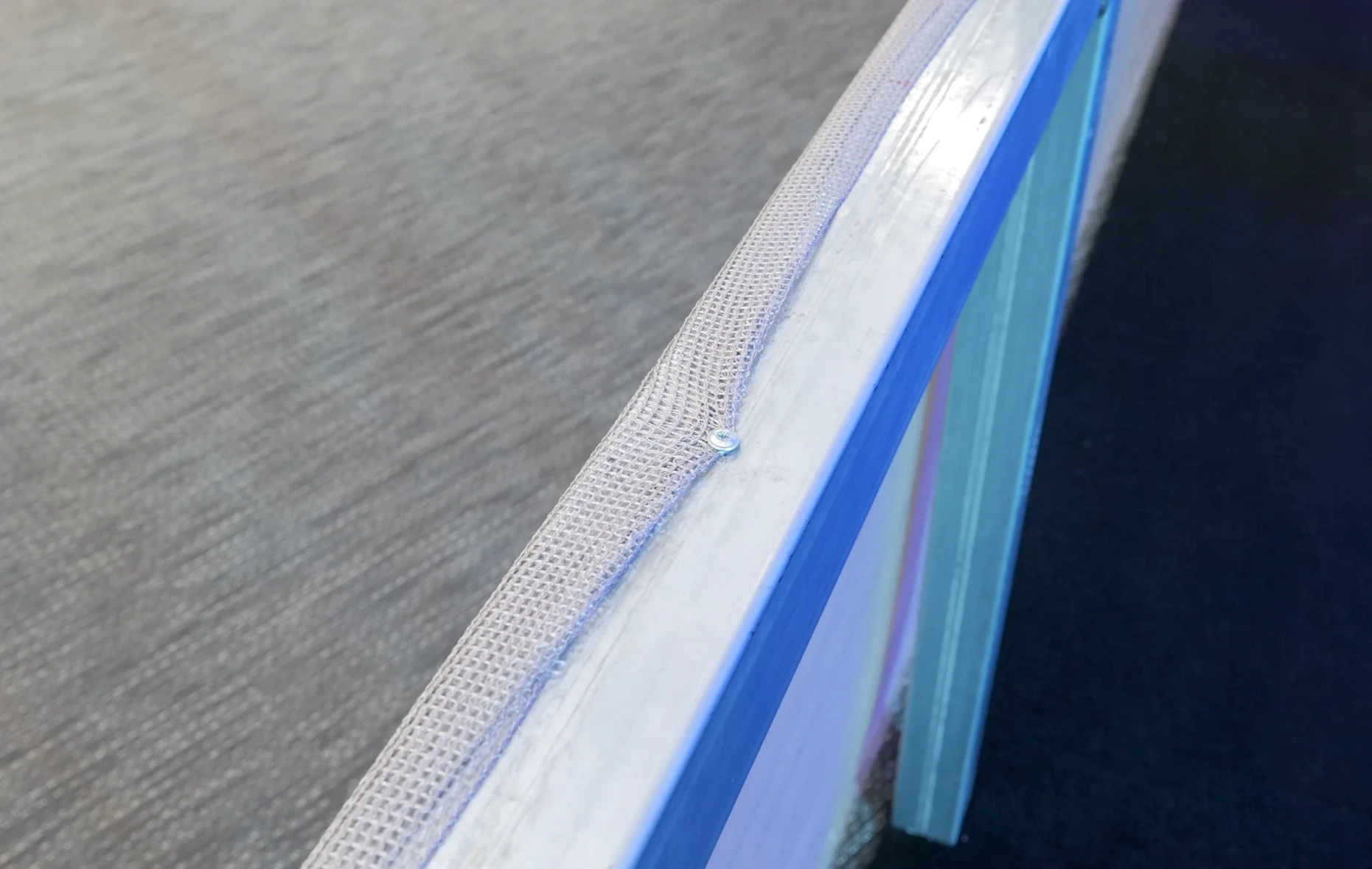 Detail of silver mesh fixed along the aluminium frame of the BAN♡ITS pavilion