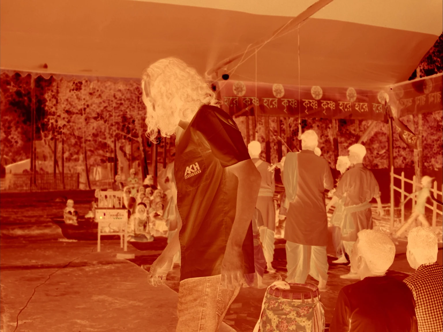 A bandit walking through a gathering beneath a decorated pavilion in an orange inverted film still