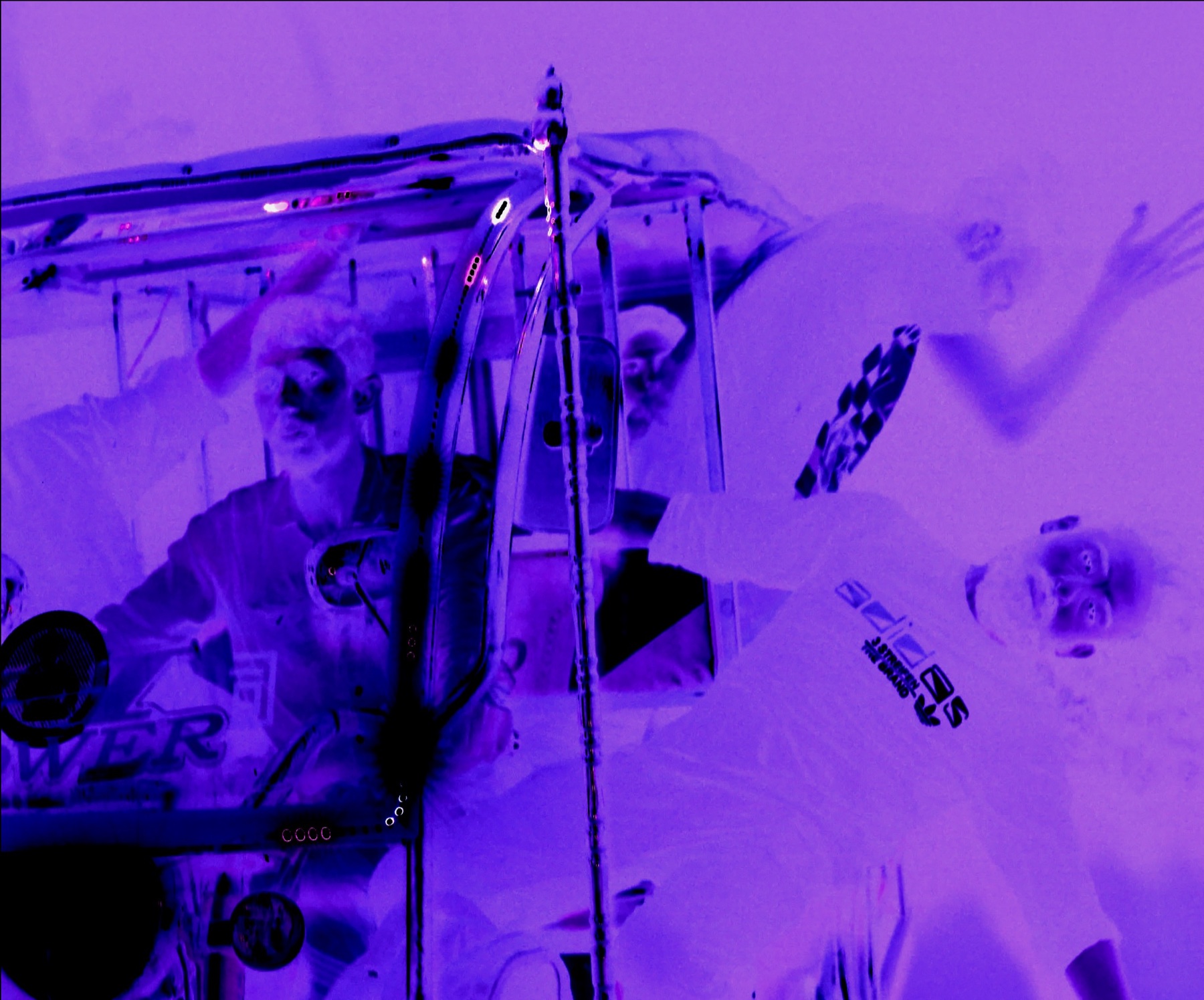 Three bandits gathered around a vehicle in a purple-tinted film still