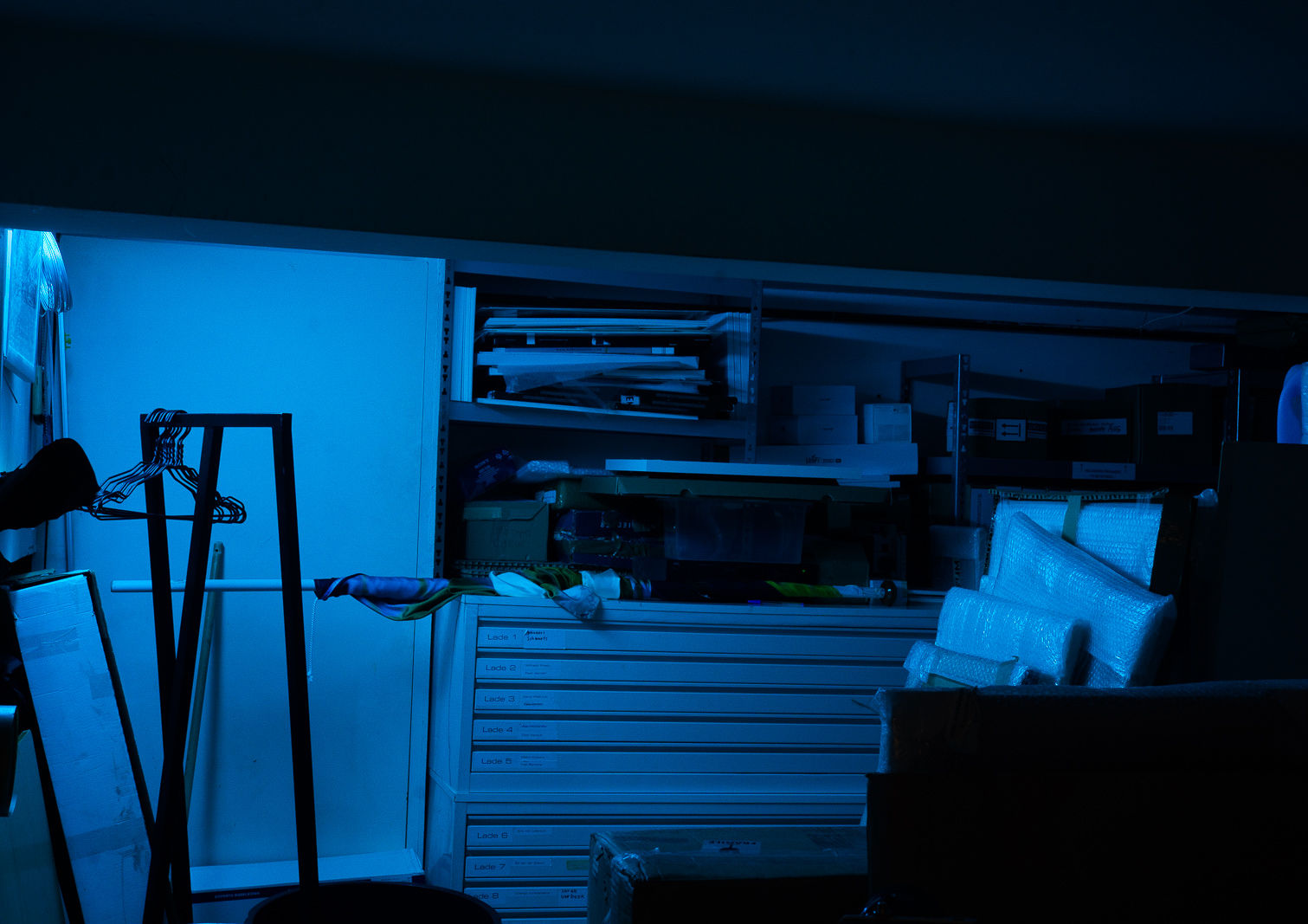 Storage doorway left ajar with a blue filter