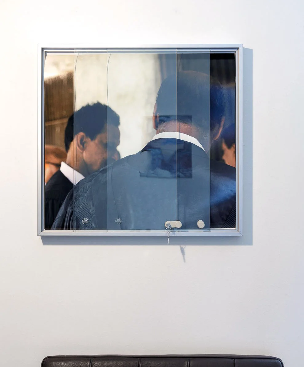 Long framed photograph installed above ajar glass doors