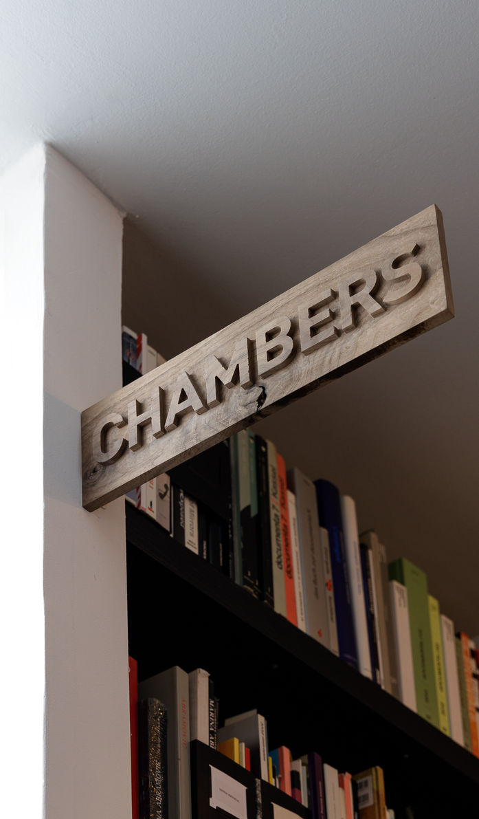 Wooden Chambers sign installed above a doorway