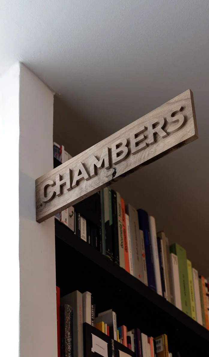 Wooden Chambers sign installed above a doorway
