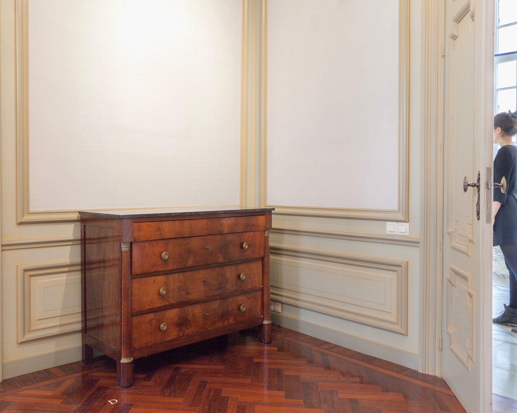 A performed encounter inside a sparsely furnished room