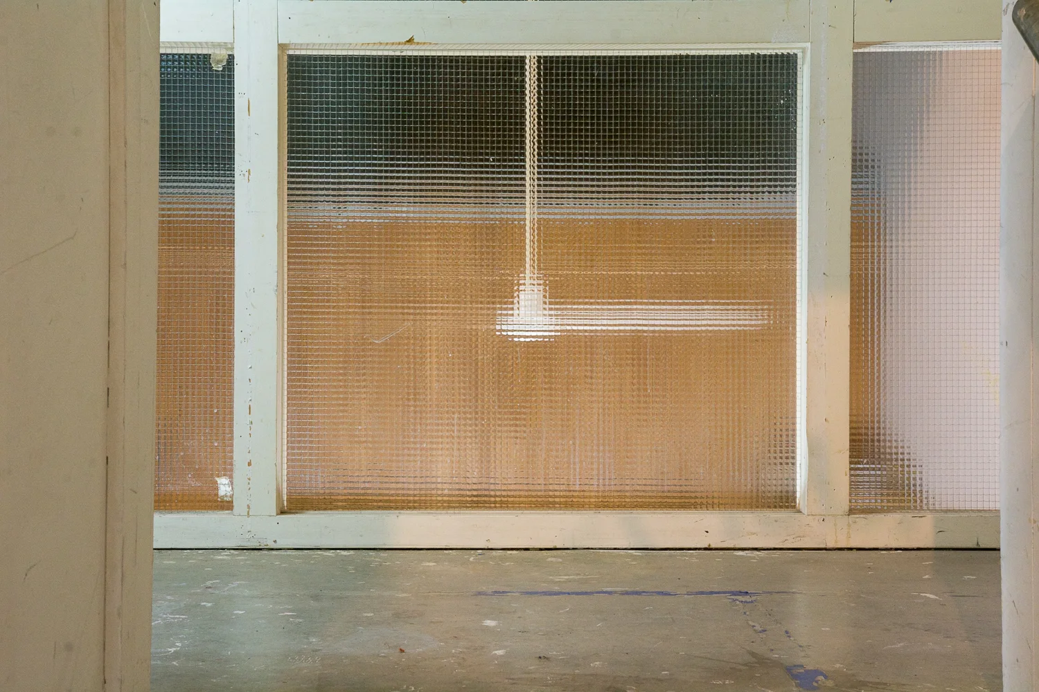Hanging fan seen through wired glass panes