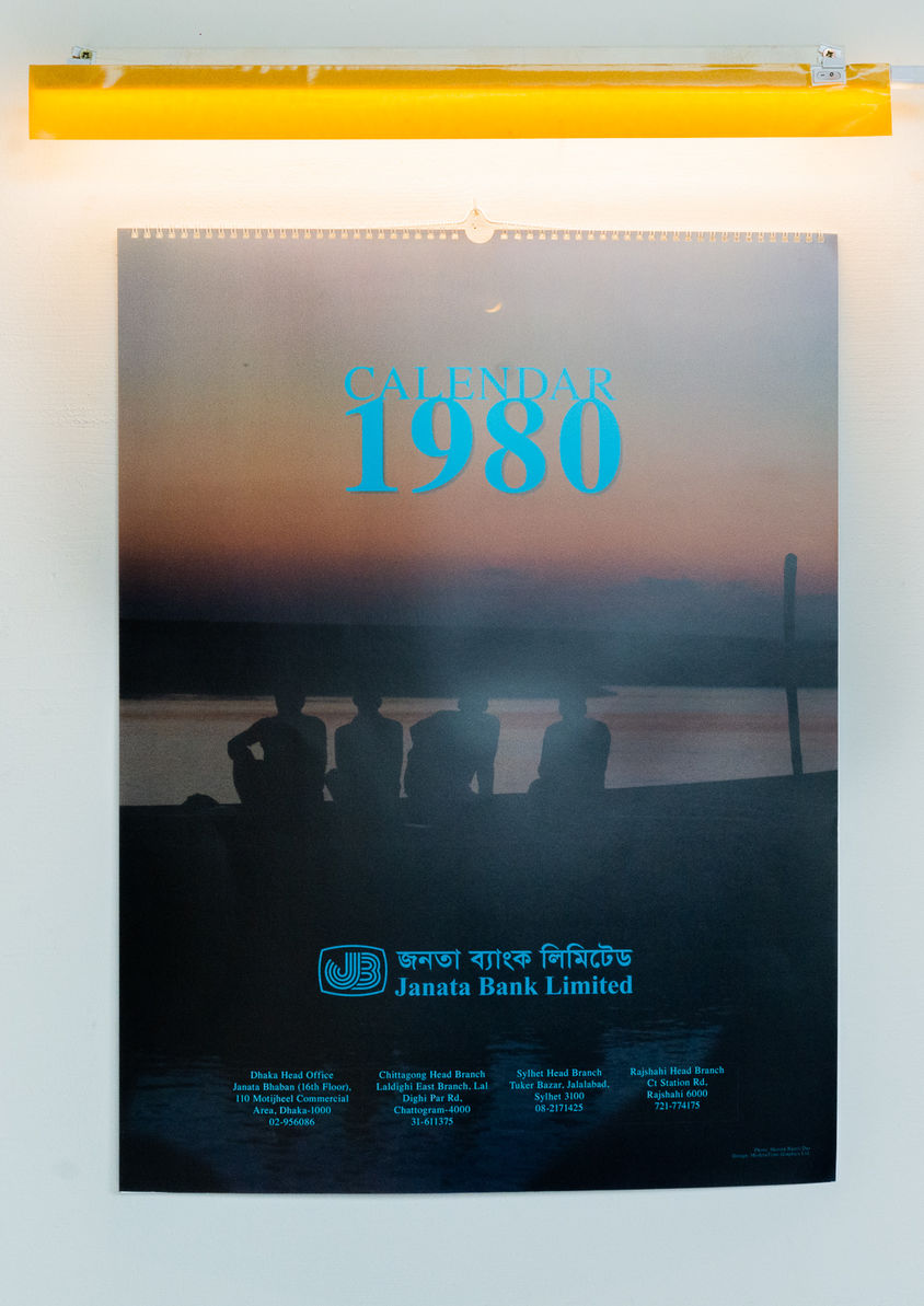 Closed reconstructed Janata Bank calendar from 1980 beneath a yellow light