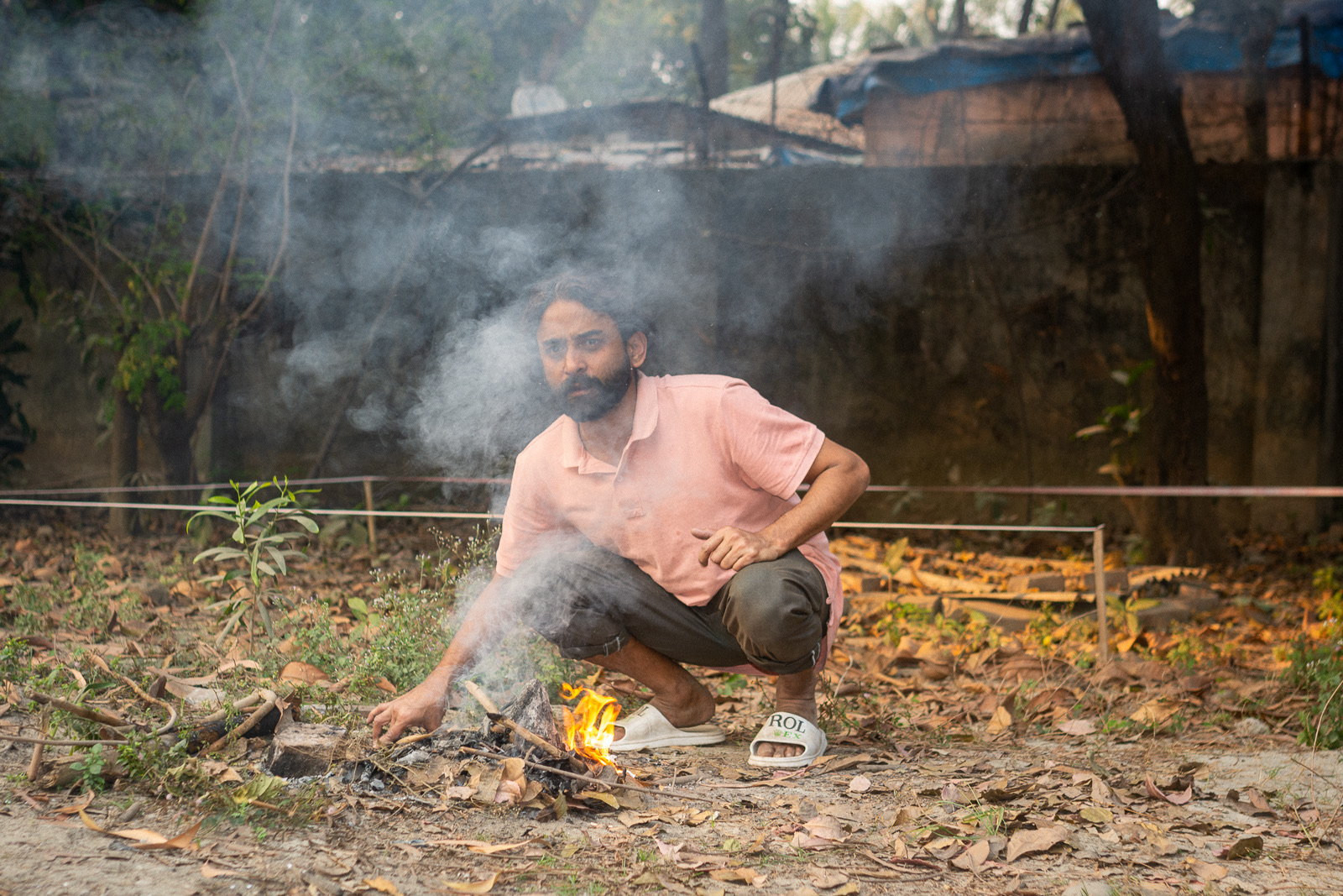 A caretaker tends a small fire during Faydabad For-Sale