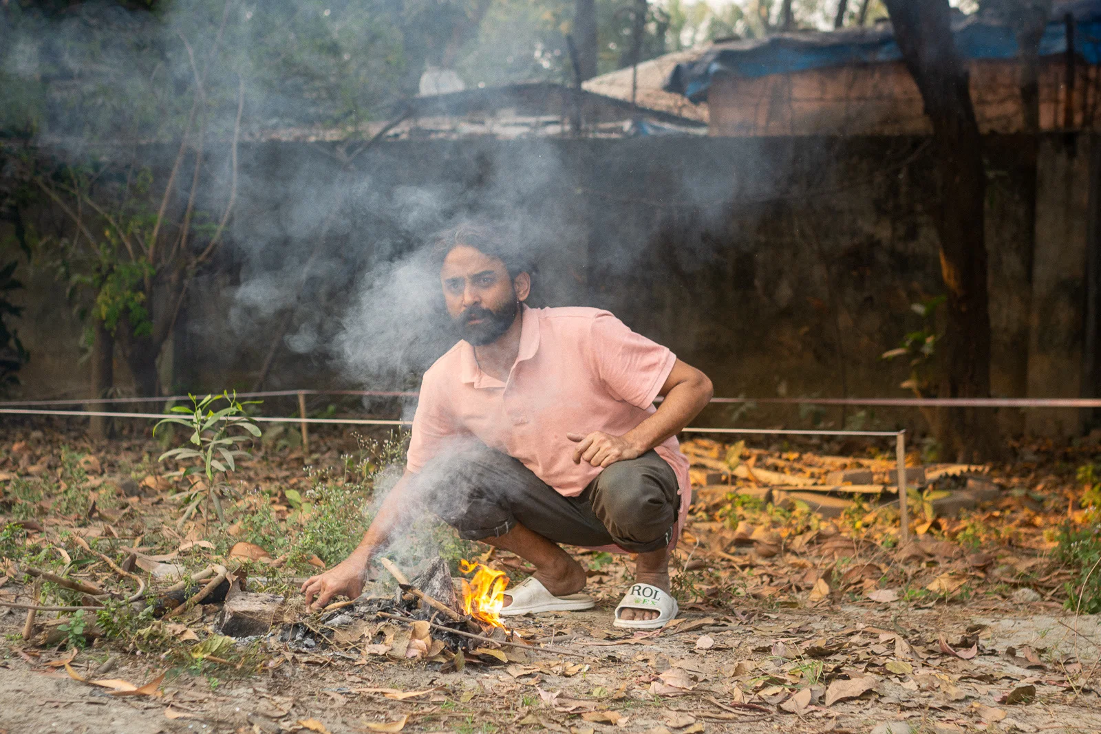 A caretaker tends a small fire during Faydabad For-Sale