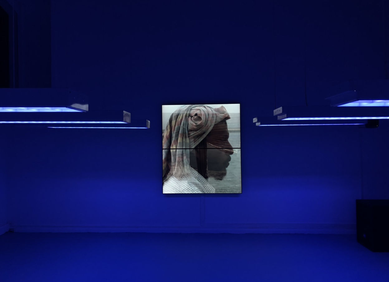 Installation view with suspended lights and film projection