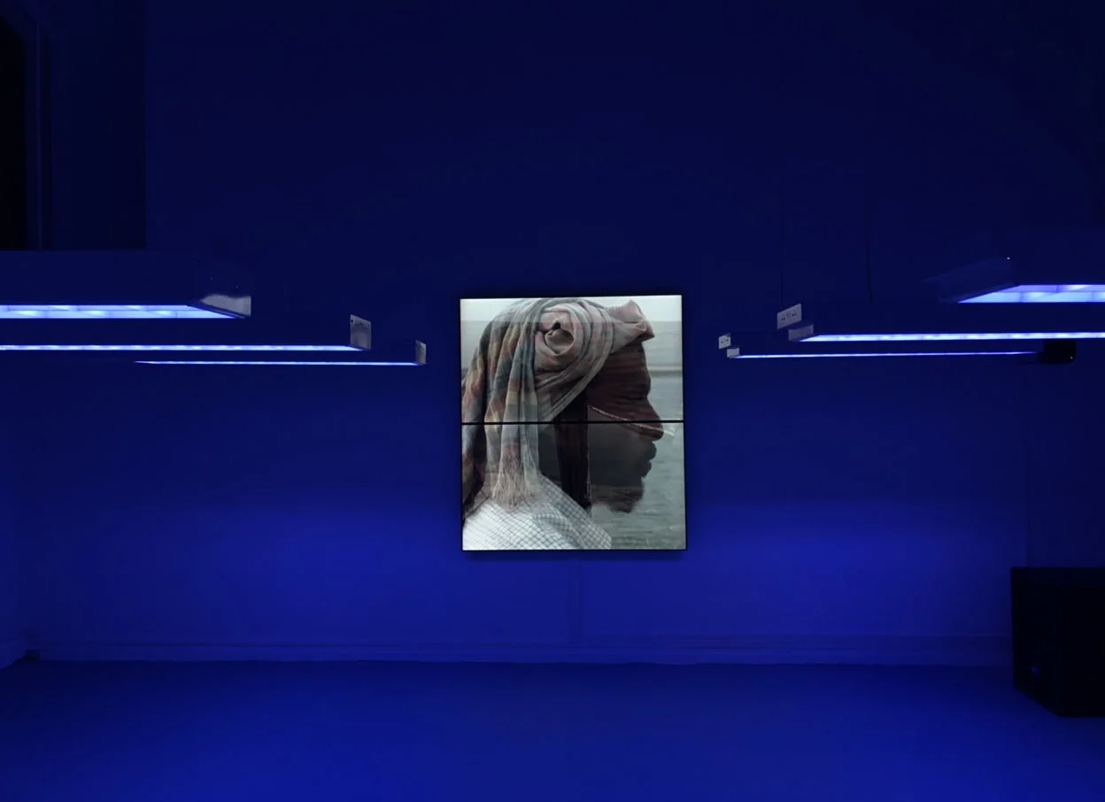 Installation view with suspended lights and film projection